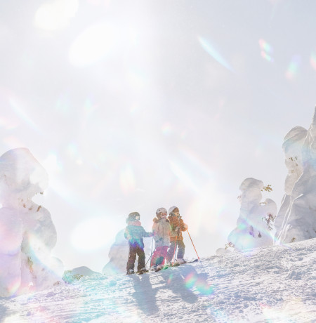 Kids next to snow covered trees in Ruka 